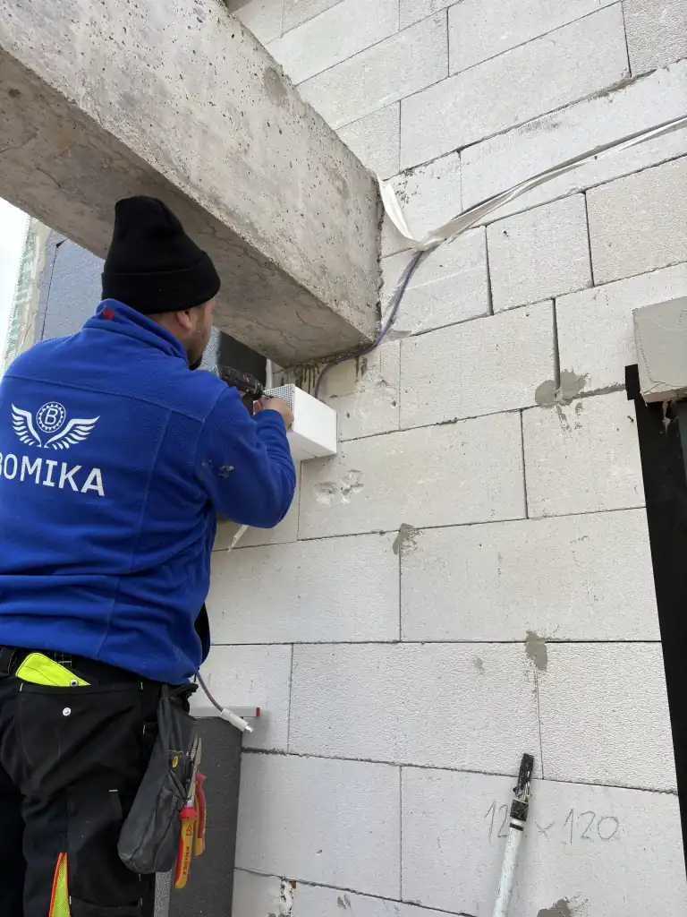 Elektrikár Bomika pri montáži vonkajšej elektroinštalácie na novostavbe